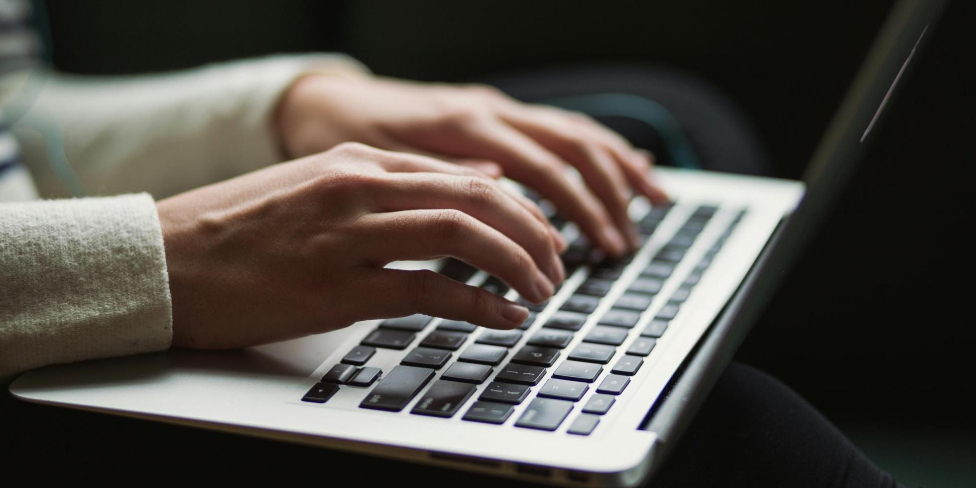 Hands typing on laptop