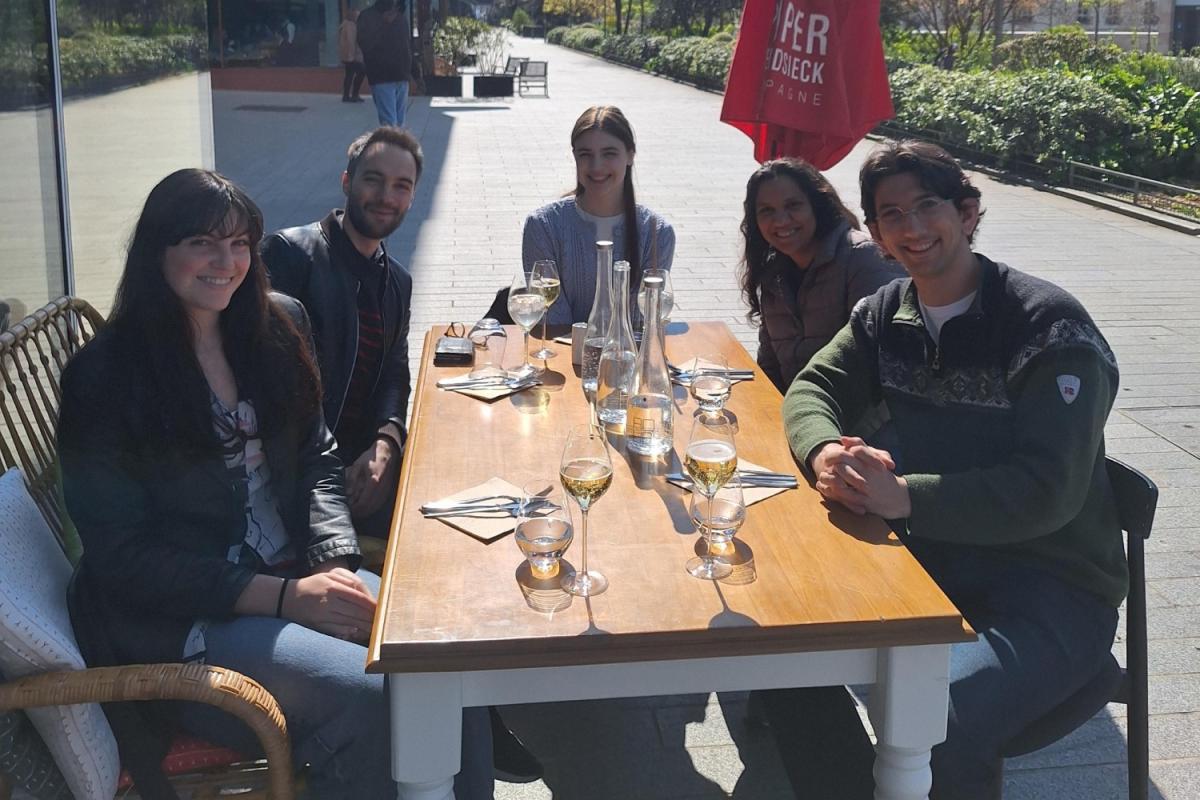 Anjli Parrin, Law School Students, and Undergraduate Interns Around a Table in Paris